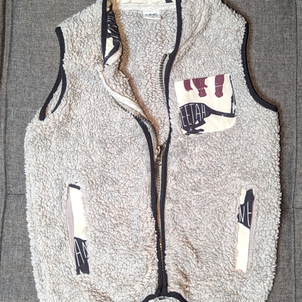 Gray fleece zip up vest with pockets and animal detail edging